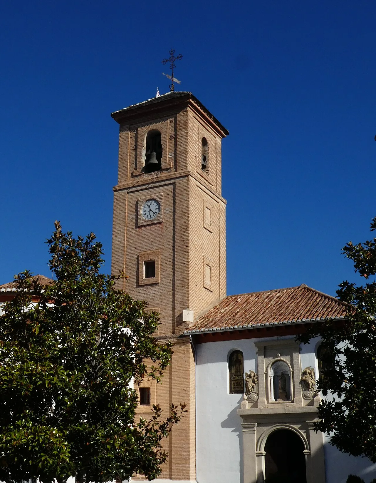 Kirchturm mit Uhr und Glockenturm in Dúrcal, Granada.