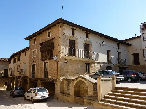 Steinernes Gebäude mit Balkonen und Stufen in Ráfales, Teruel.