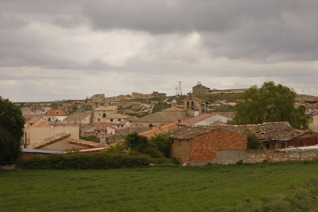 View of houses and a castle on the hill in Fuentelcésped, Burgos.