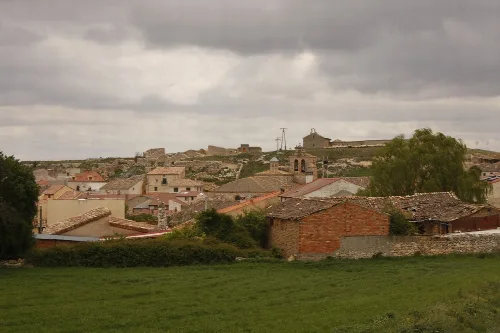 View of houses and a castle on the hill in Fuentelcésped, Burgos.