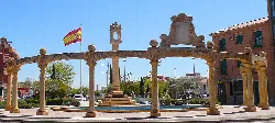 Square with columns, fountain, and flag in Torrijos, Toledo.