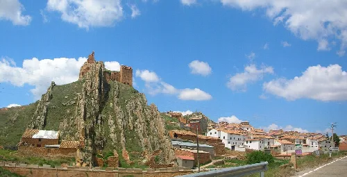 Panoramablick auf Segura de los Baños mit Burg auf Hügel und Häusern.