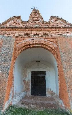 Chapel entrance with brick arch and cross at the top.