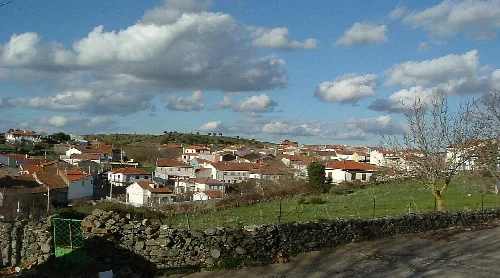 Vista de casas y cielo con nubes desde la iglesia en Escurial de la Sierra.