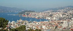 Vista panorámica del puerto y centro de Vigo con edificios y agua.
