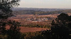 Paisaje con vista panorámica de Fontanars y campos agrícolas al atardecer.