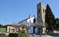 Pfarrkirche von Sant Vicenç mit steinernem Turm und geschnittenen Bäumen in Vallromanes.