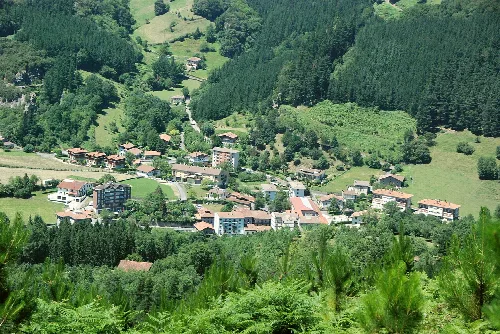 Vista panorámica de Mañaria con casas y árboles en un valle.