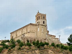 San Lorenzo Church in Magallón on a hill with vegetation.