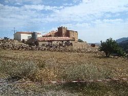 Stone tower with walls in a rural landscape in Cantavieja.