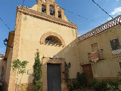 Fachada de una iglesia con campanario y puertas de madera en Segart.