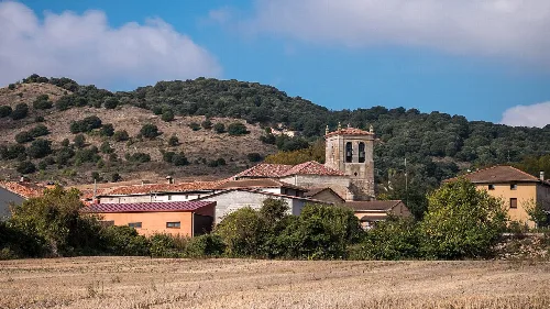 View of a town with church and hills in the background.