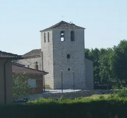Steinerner Kirchturm mit Bogenfenstern und Ziegeldach.