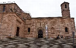 Stone church facade with stairs and tower in Linares.