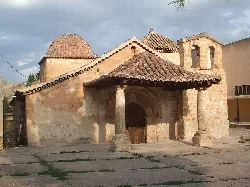 Small church with tiled roofs and columns in Ademuz.