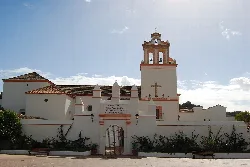 White façade and tower of the sanctuary in Jimena de la Frontera.