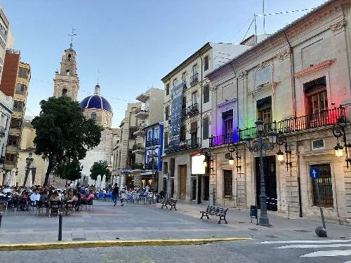 Rathausplatz in Sueca mit Cafés und historischen Gebäuden an einem Sommertag.