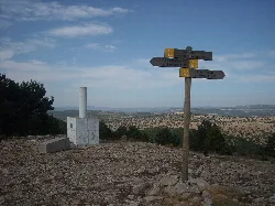 Cruz en un mirador con señalización y vistas a la comarca en Castielfabib.