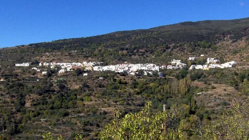 Vista panorámica de un pueblo con casas blancas en una ladera montañosa.