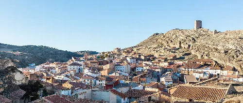 Blick auf weiße Häuser und eine Burg auf dem Hügel in La Hoz de la Vieja.