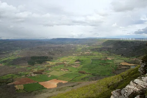 Paisaje del valle con campos verdes y colinas desde un mirador.