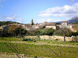Paisaje de Ábalos con casas, iglesia y montañas.