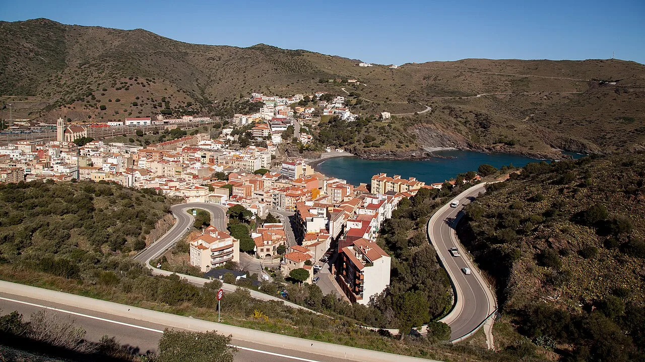 Panoramablick auf Portbou mit Häusern, Bucht und Bergen.