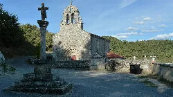 Steinernes Kirchenportal mit Kreuz im Vordergrund.