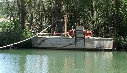Floating platform on the Pisuerga River with trees in the background.