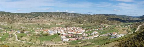 Panoramablick auf Zafrilla mit Häusern und Straßen in einer hügeligen Landschaft.