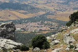 Vista panorámica de Villanueva de la Concepción desde un mirador con rocas y vegetación.
