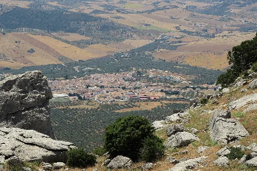 Panoramablick auf Villanueva de la Concepción von einem Aussichtspunkt mit Felsen und Vegetation.