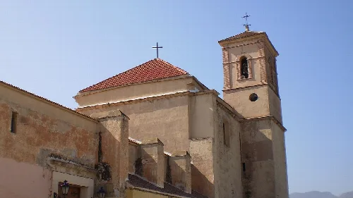 Iglesia con torre y tejado de tejas rojas en Pechina.
