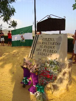 Monolito con flores y bandera andaluza en Gilena.