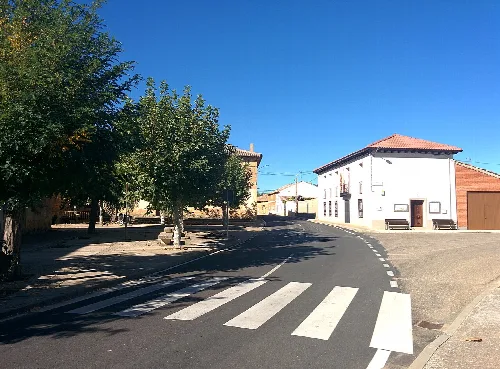 Calle con árboles y edificios en Villanueva de los Caballeros.