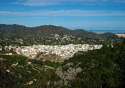 View of Pego with houses, mountains, and the sea in the distance.