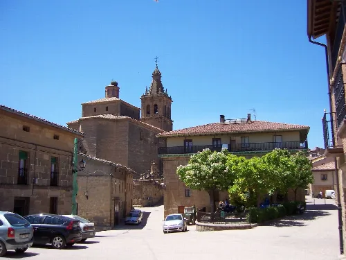 Hauptplatz von Briñas mit Kirche und Gebäuden an einem sonnigen Tag.