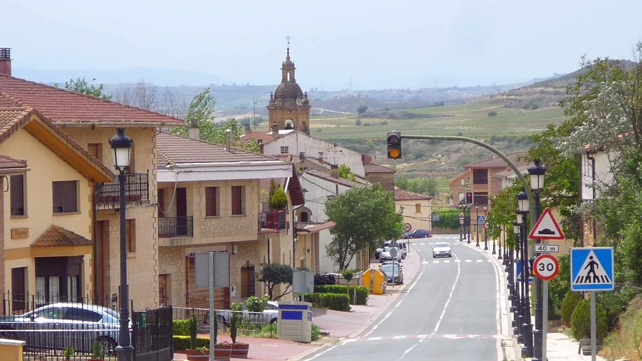 Streets of Baños de Ebro with houses and a church in the background.