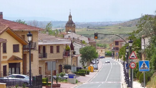 Straßen von Baños de Ebro mit Häusern und einer Kirche im Hintergrund.