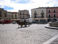Platz mit Kutsche, Autos und historischen Gebäuden in Trujillo.