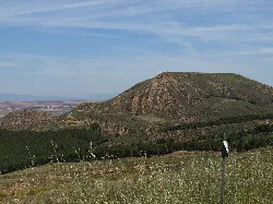Seitlicher Blick auf einen Hügel mit Vegetation und blauem Himmel in Alcalá de Henares.