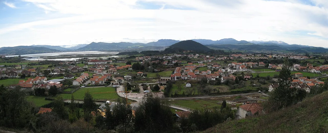 Panoramic landscape of Argoños with houses, fields, and mountains.