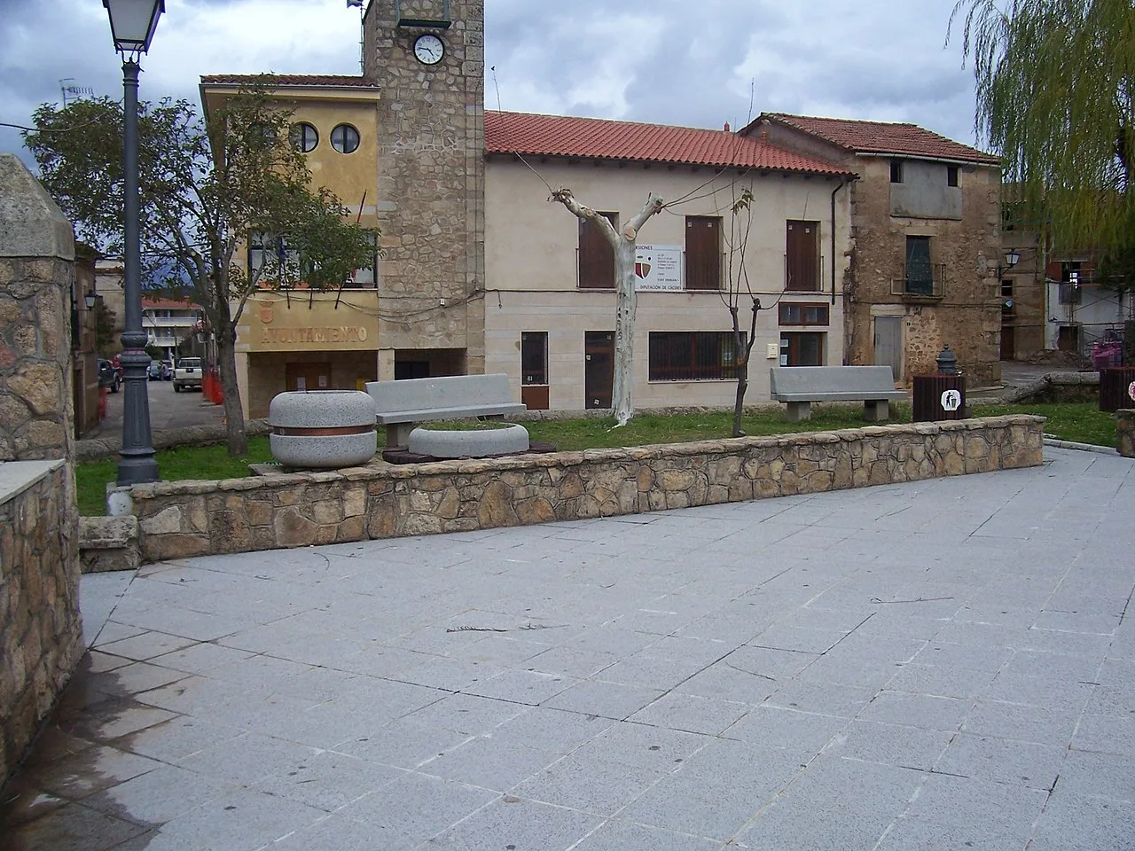 Square with benches, trees, and buildings in Villasbuenas de Gata.