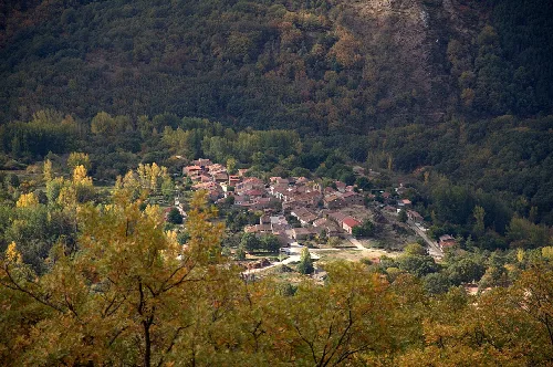 View of a village surrounded by trees and mountains in Guadalajara