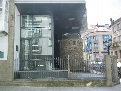 Edificio con estructura moderna de cristal y base de piedra en Lalín.