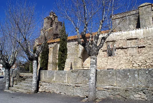 Steinfassade und Bäume bei der Kirche in Monleras.