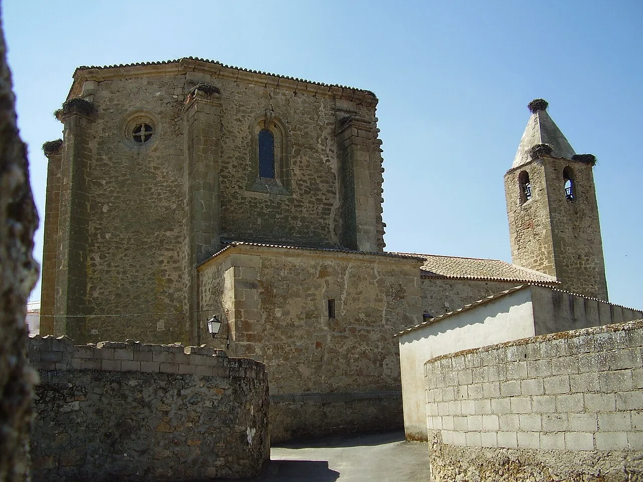 Iglesia de piedra con torre y campanario en Torrequemada