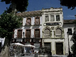 Edificio con casas antiguas y restaurante en la planta baja en Baza.