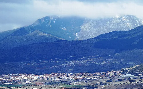 Blick auf eine Stadt in einem Tal, umgeben von Bergen.
