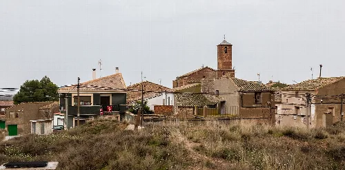 Houses and a church with a bell tower in Pozuelo de Aragón.